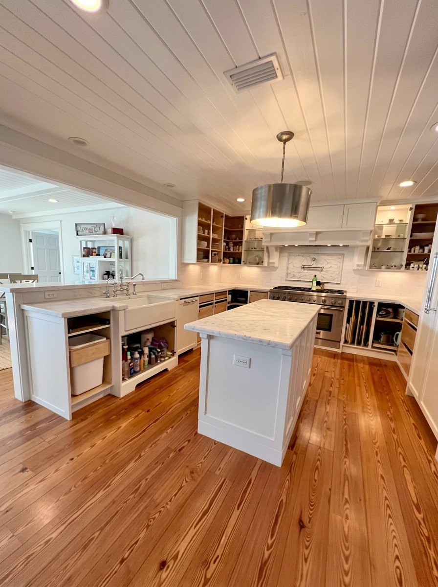 Custom white shaker cabinetry with stone countertops and heart pine floors in a St. Johns County FL kitchen remodel