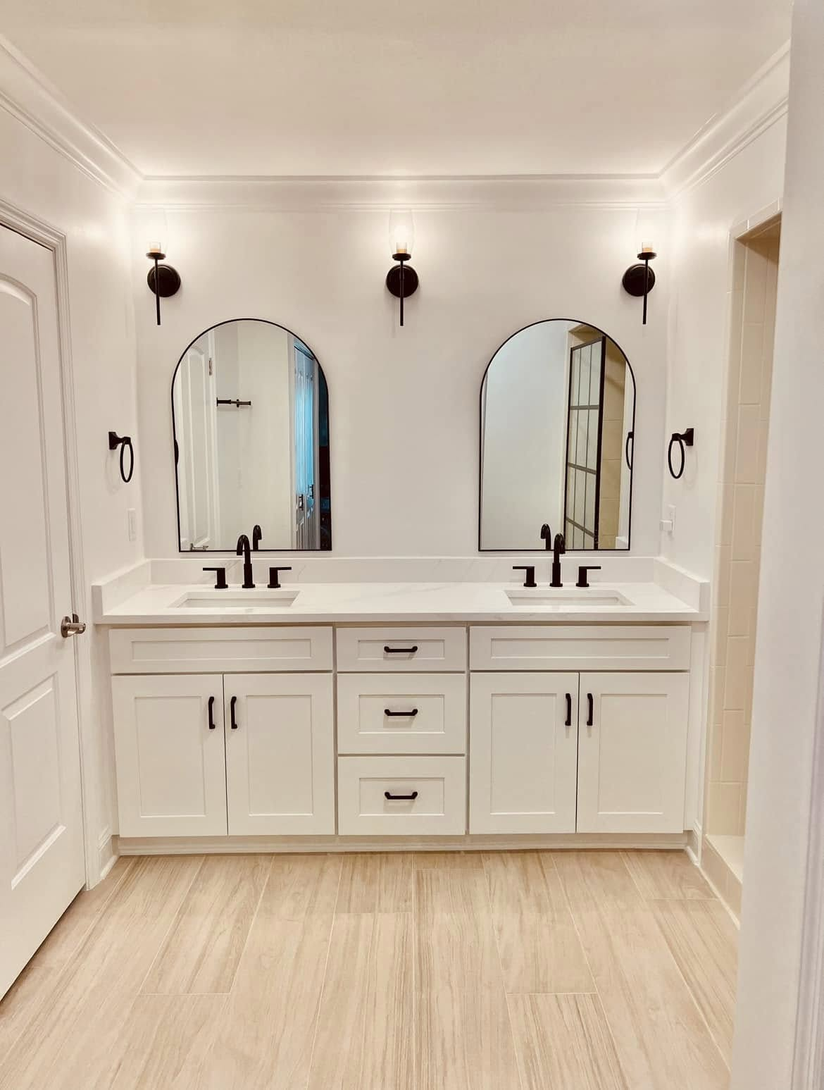 Remodeled master bathroom with custom double vanity, quartz countertop, arched mirrors and tile flooring in St. Johns County, FL